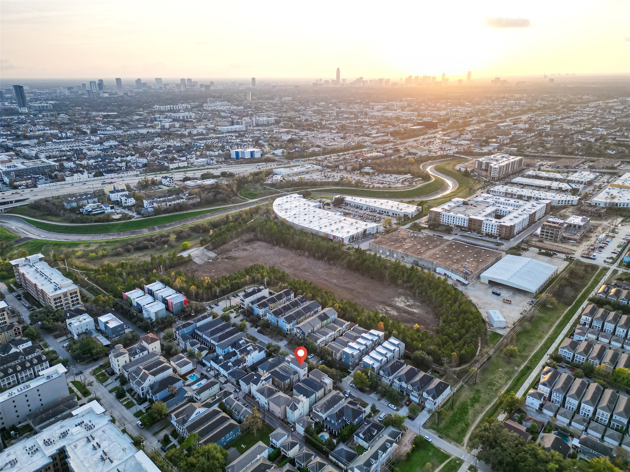 620 Rutland Street, Unit A Houston, TX 77007 - Photo 43 of 46 This aerial photo showcases a residential neighborhood with modern homes, surrounded by greenery and adjacent to a large urban area. The city skyline is visible in the distance, suggesting convenient access to urban amenities while enjoying a suburban setting.