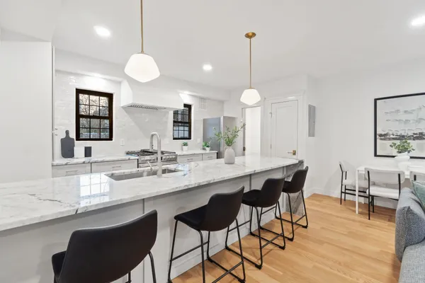 a kitchen with a dining table chairs and wooden floor