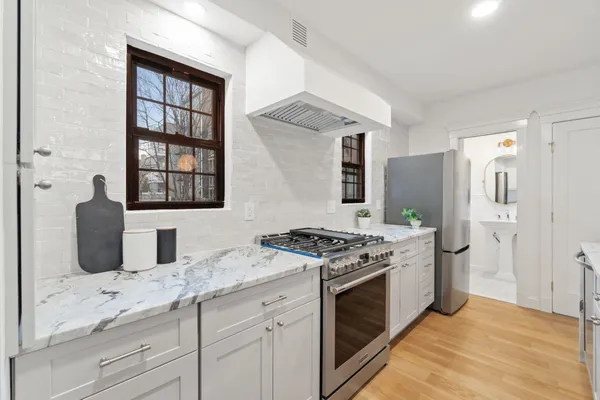 a large white kitchen with a large window