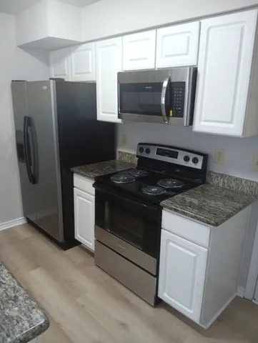 a kitchen with stainless steel appliances granite countertop a refrigerator and a stove