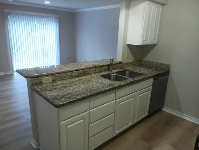 a kitchen with granite countertop cabinets and window