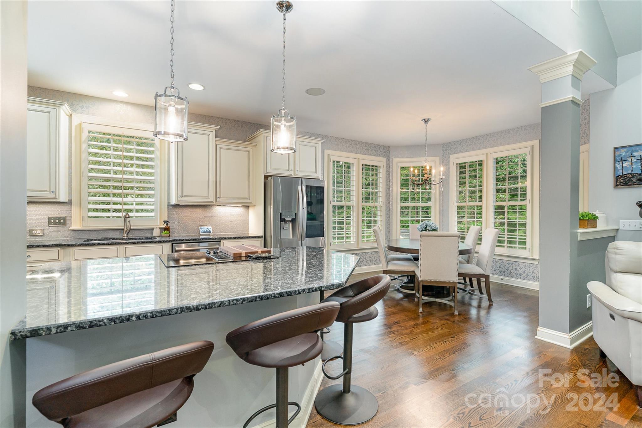 5324 Maddox Court Fort Mill, SC 29708 - Photo 15 of 48 an open kitchen with granite countertop a stove a sink a dining table and chairs with wooden floor