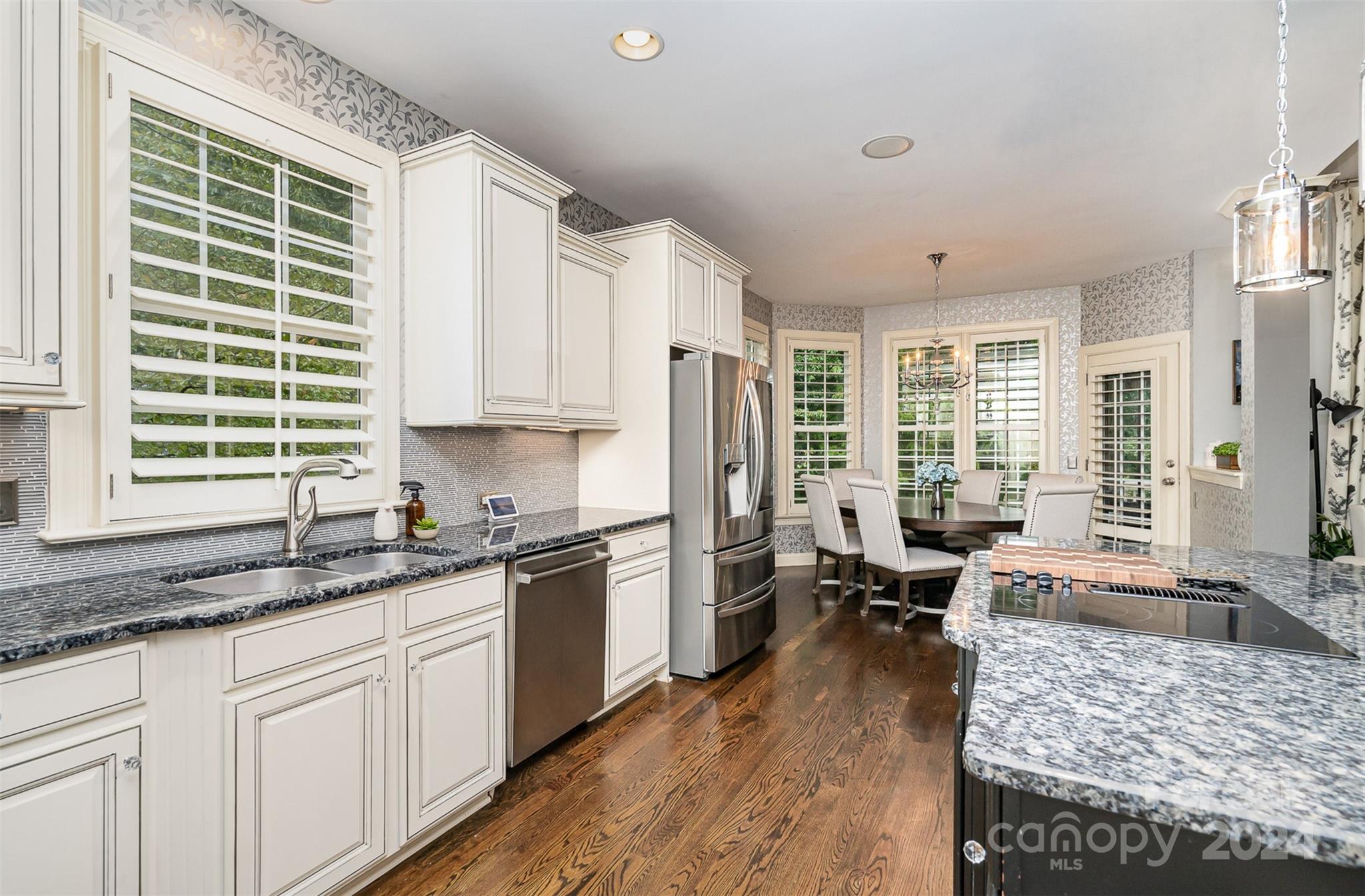 5324 Maddox Court Fort Mill, SC 29708 - Photo 17 of 48 a kitchen with granite countertop a stove a sink a refrigerator and white cabinets with wooden floor