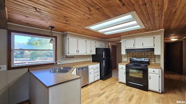 a kitchen with cabinets appliances a sink and a window