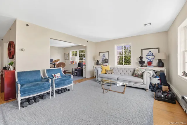 a living room with furniture a large window and wooden floor