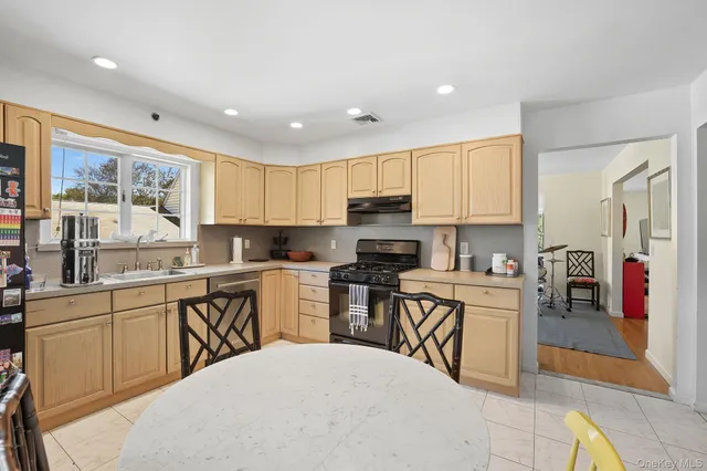 a kitchen with a table chairs microwave and cabinets