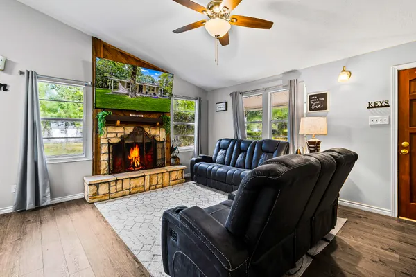 a view of a house with a yard and large trees