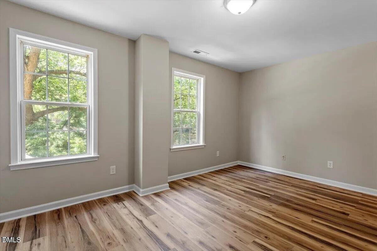 1611 Poole Road Raleigh, NC 27610 - Photo 13 of 19 a view of an empty room with wooden floor and a window