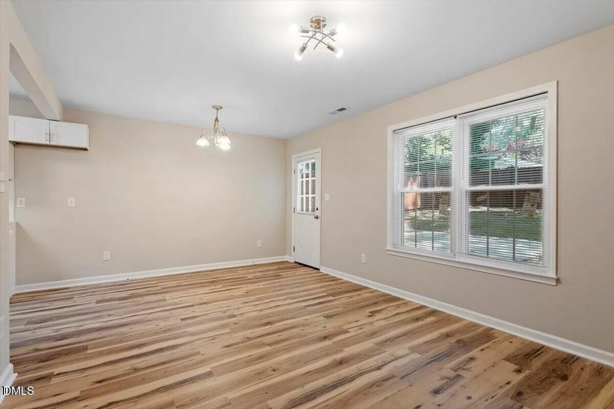 1611 Poole Road Raleigh, NC 27610 - Photo 16 of 19 a view of an empty room with wooden floor and a window