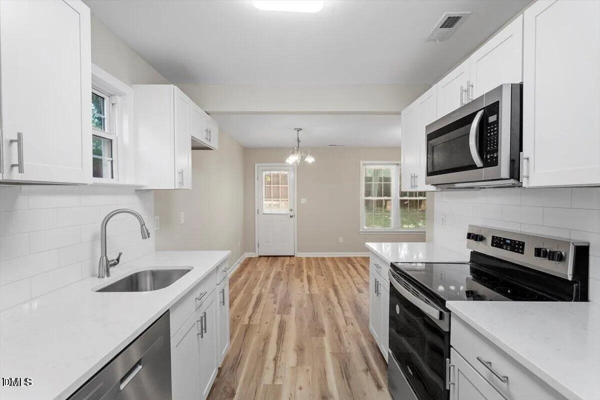1611 Poole Road Raleigh, NC 27610 - Photo 7 of 19 a kitchen with a sink stove and microwave
