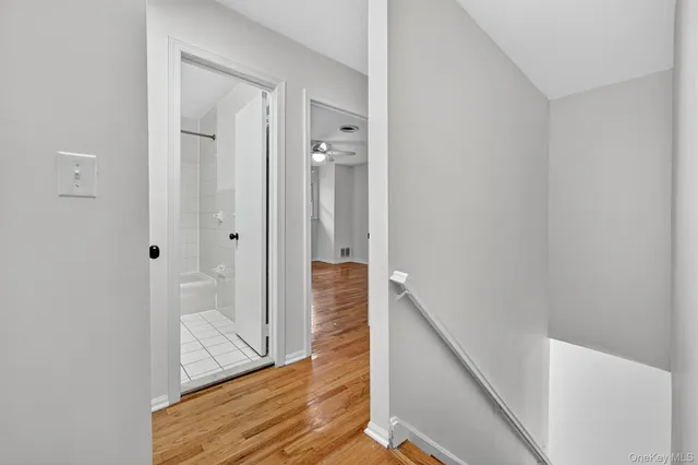 a view of a hallway with wooden floor and staircase