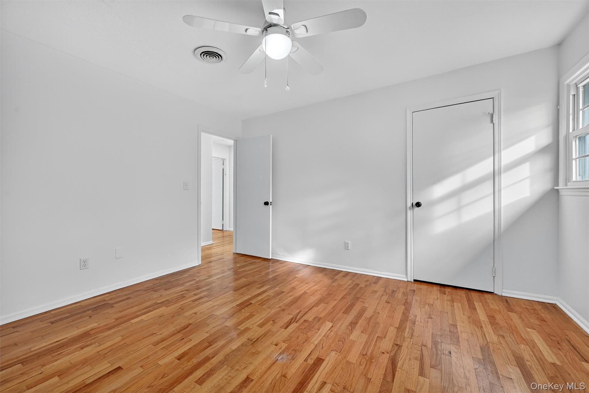 28 Alan Road Spring Valley, NY 10977 - Photo 19 of 39 an empty room with wooden floor fan and windows