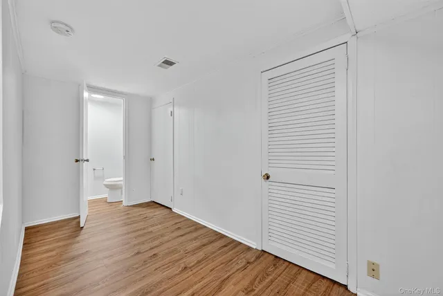 a view of a room with wooden floor and white walls