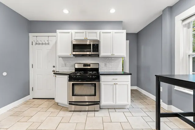 a kitchen with stainless steel appliances granite countertop a stove a microwave and a refrigerator