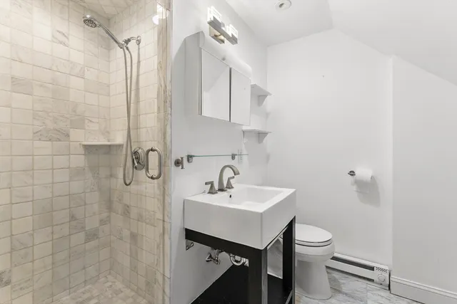 a bathroom with a sink a toilet and shower