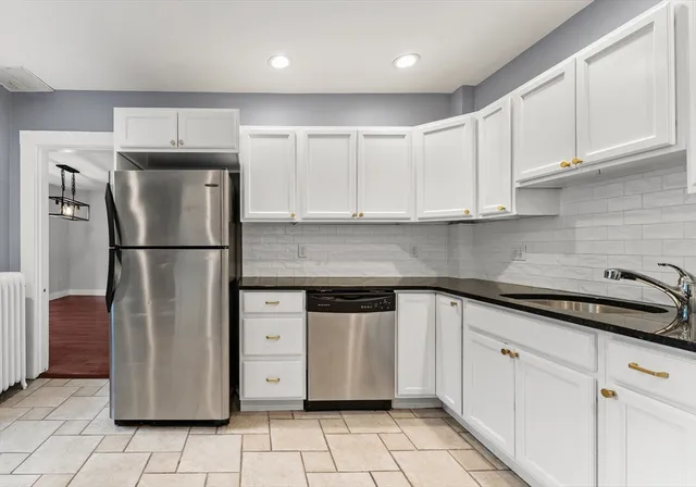 a kitchen with stainless steel appliances granite countertop a refrigerator and a sink