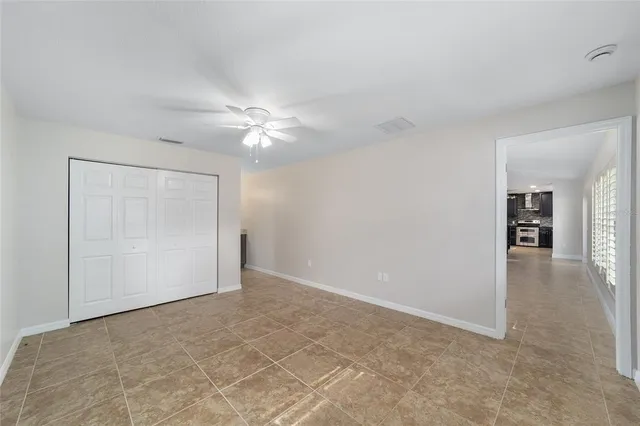 an empty room with closet and a ceiling fan