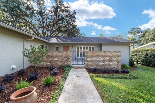 a view of house with a yard and potted plants