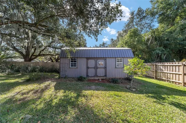 a view of a house with a yard and fence