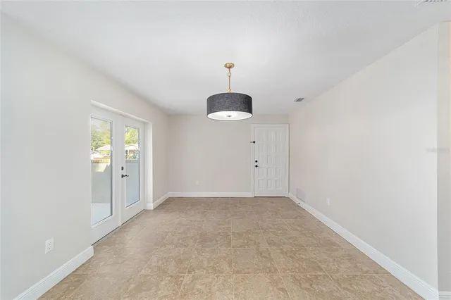 an empty room with windows and cabinet