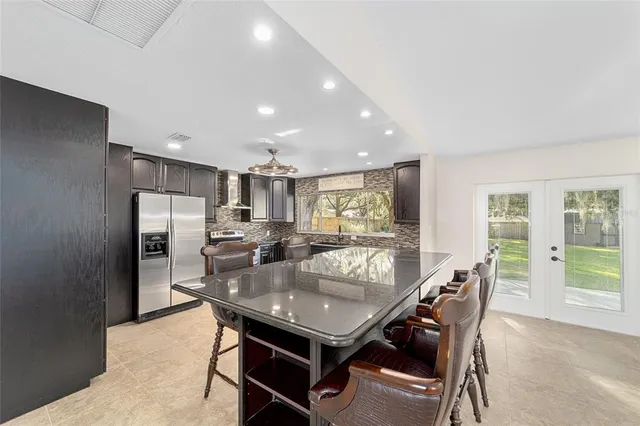 a dining room with stainless steel appliances furniture a window and kitchen view