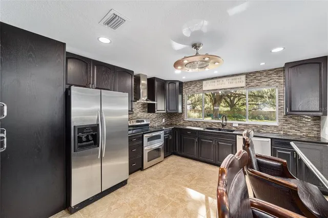 a kitchen with stainless steel appliances granite countertop a stove refrigerator and microwave
