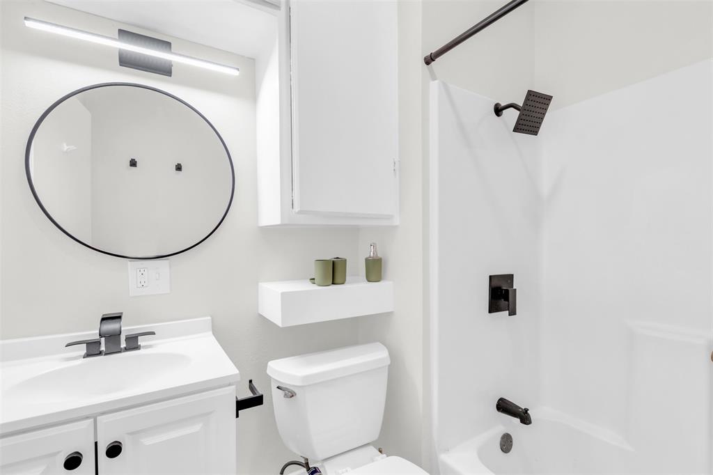 4121 Junius Street, Unit 4123 Dallas, TX 75246 - Photo 17 of 23 a bathroom with a sink a mirror a toilet and a mirror