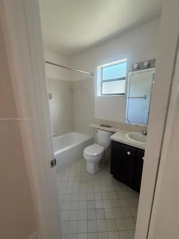 a bathroom with a granite countertop sink toilet a mirror and shower