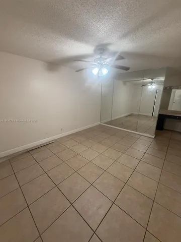 an empty room with a ceiling fan and entryway