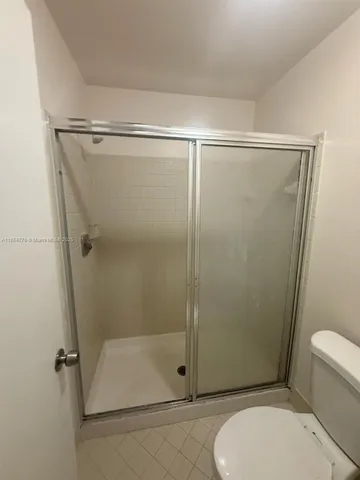 a bathroom with a toilet and a shower