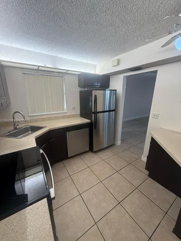 a kitchen with a sink a refrigerator and cabinets