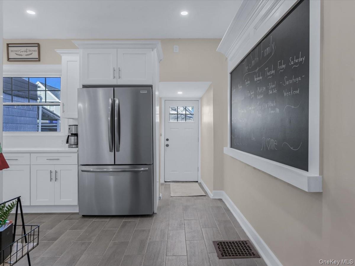 80-49 88th Avenue Queens, NY 11421 - Photo 11 of 28 a kitchen with a refrigerator a stove top oven and wooden floor