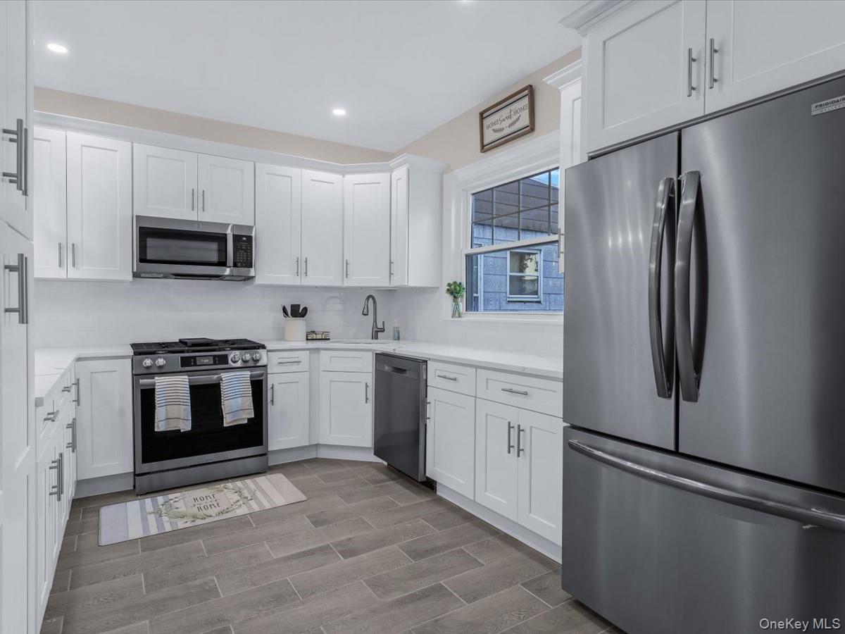 80-49 88th Avenue Queens, NY 11421 - Photo 12 of 28 a kitchen with stainless steel appliances and white cabinets