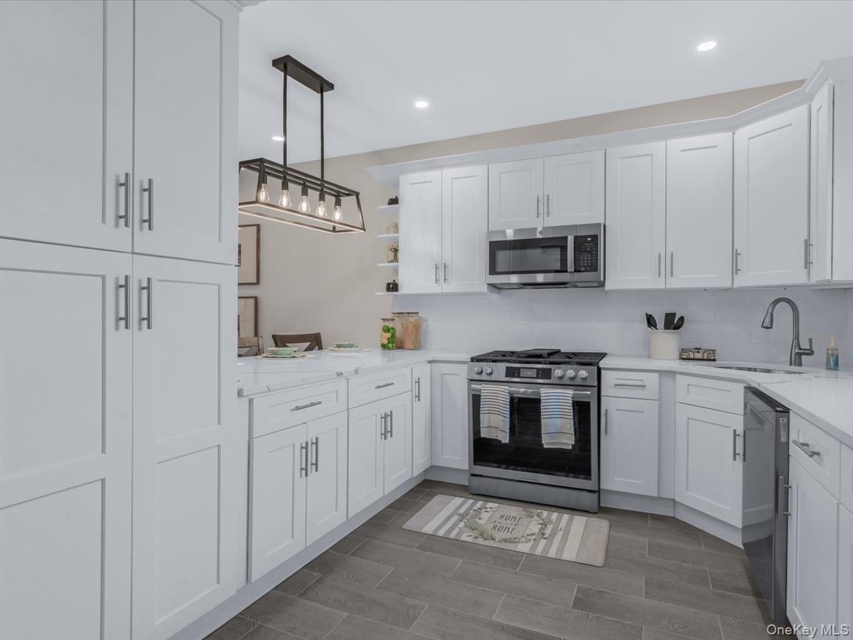 80-49 88th Avenue Queens, NY 11421 - Photo 13 of 28 a kitchen with stainless steel appliances granite countertop a stove a sink and a refrigerator