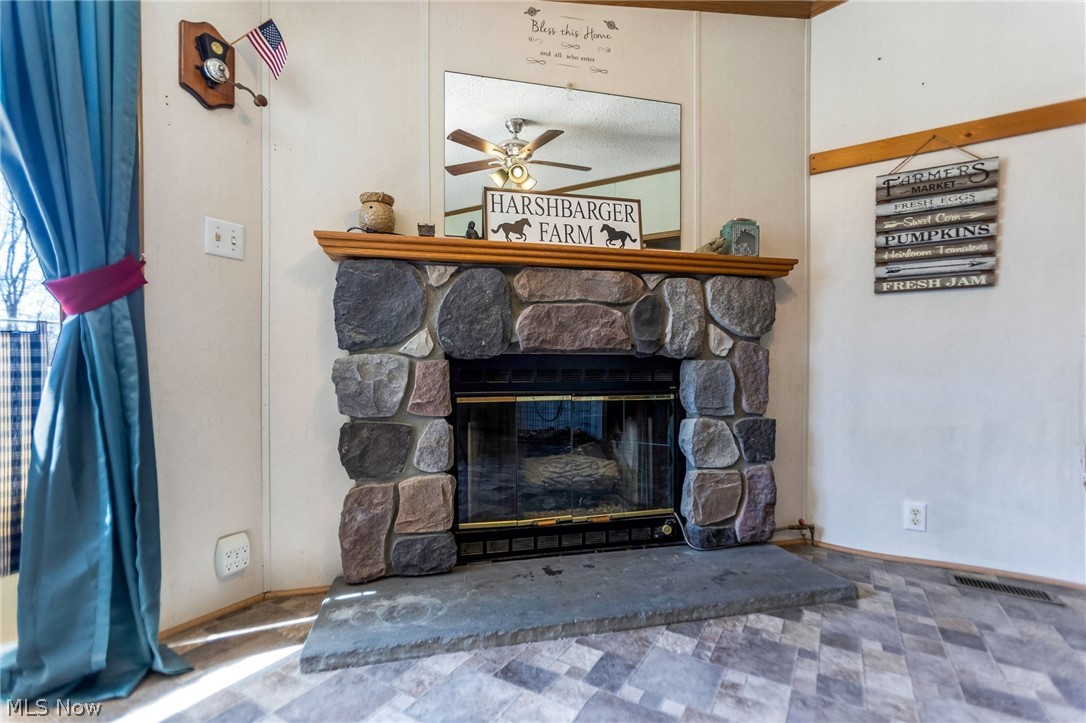 4502 Clover Road Cumberland, OH 43732 - Photo 15 of 38 Detailed view of a ceiling fan and a stone fireplace