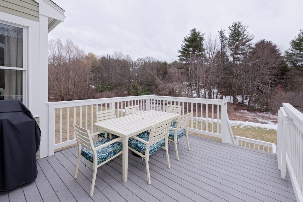 12 Cider Mill Road Stow, MA 01775 - Photo 42 of 42 a view of a roof deck with table and chairs with wooden floor and fence