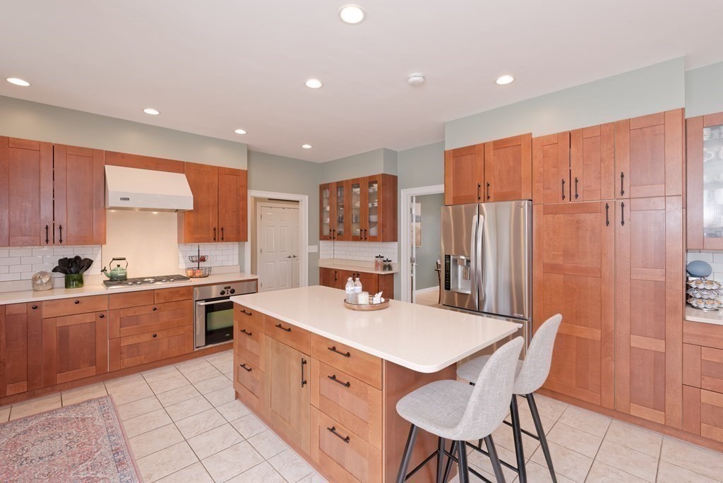 12 Cider Mill Road Stow, MA 01775 - Photo 7 of 42 a kitchen with stainless steel appliances granite countertop a table chairs sink and cabinets