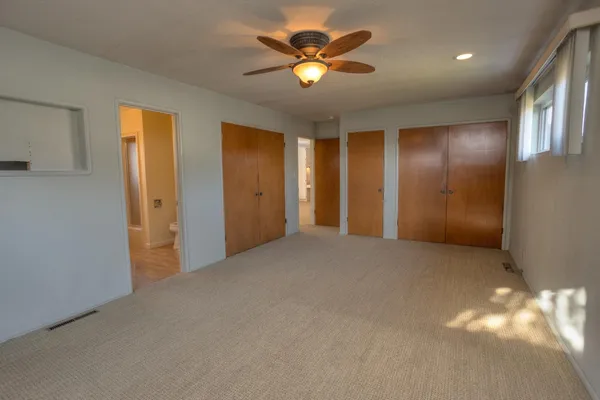 a view of an empty room with a ceiling fan