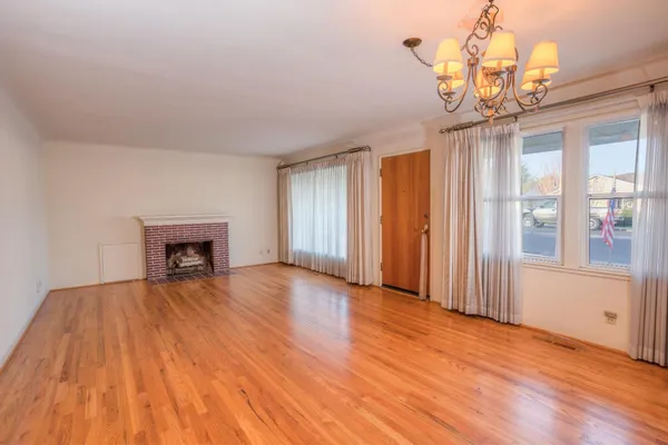 a view of empty room with wooden floor and fireplace
