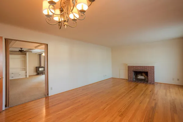 a view of empty room with wooden floor and fireplace