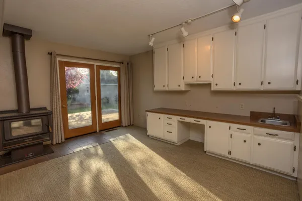 a kitchen with granite countertop a stove a sink and a refrigerator