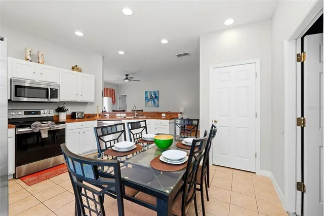 a kitchen with a dining table chairs and refrigerator