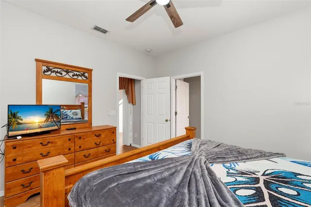 a bedroom with a bed and a flat tv screen on the dresser