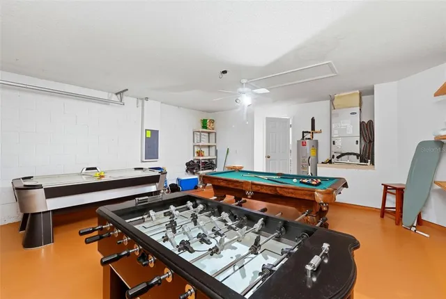 a living room with furniture pool table and windows