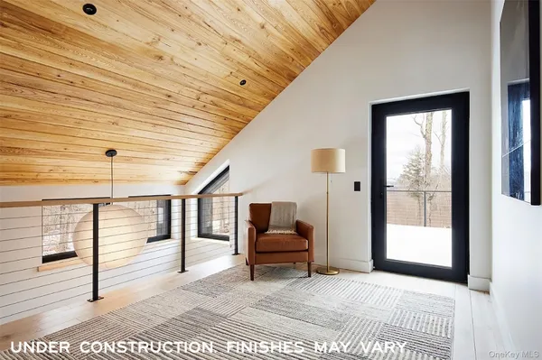 a view of a hallway with the couches and dining room view
