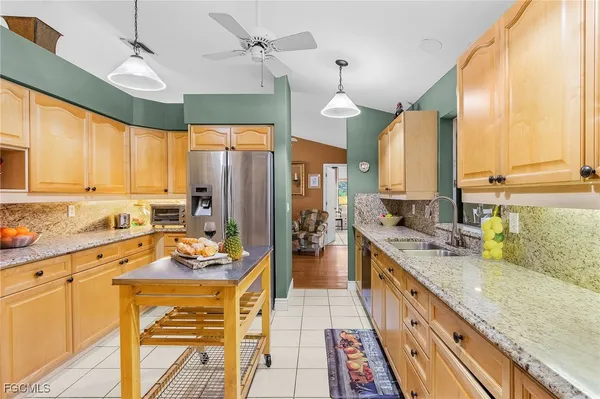 a kitchen with stainless steel appliances kitchen island granite countertop a sink stove and cabinets