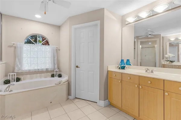 a bathroom with a tub sink and mirror