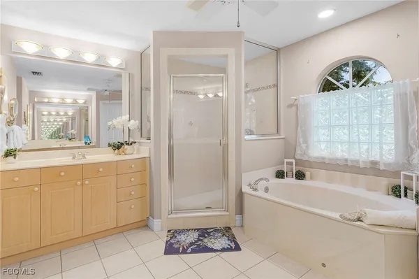 a spacious bathroom with a tub a sink and mirror