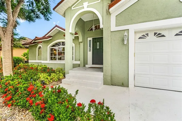 a view of a front of a house with a flower garden
