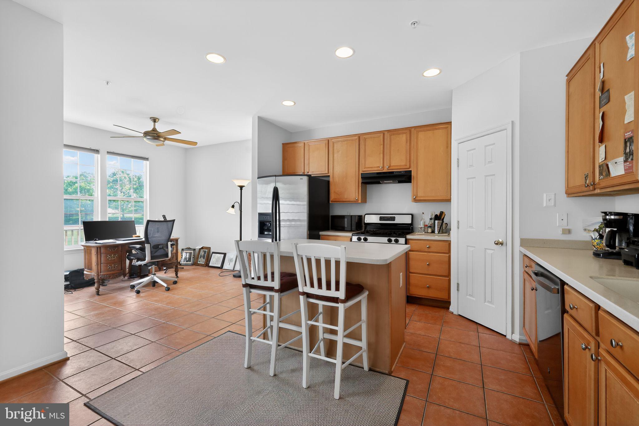 1034 Meandering Way Odenton, MD 21113 - Photo 13 of 30 a kitchen with stainless steel appliances kitchen island granite countertop a sink a stove a refrigerator cabinets and a dining table